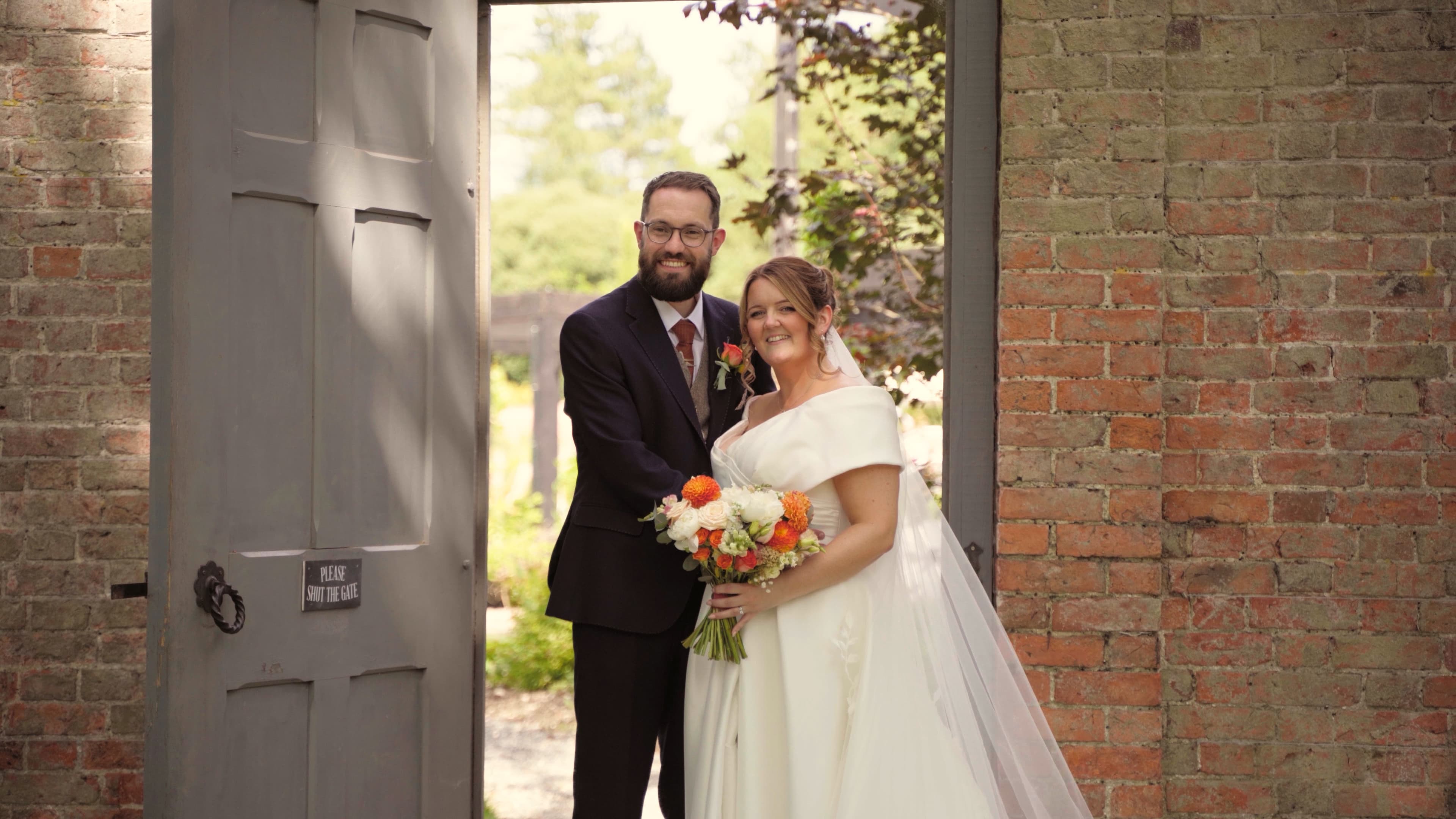Lewis and Sarah strolling through their venue gardens